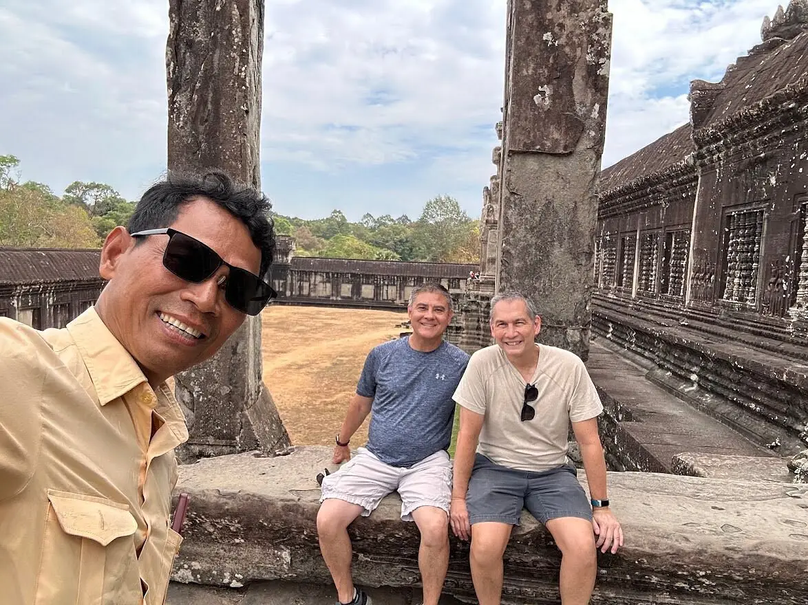 San Park taking a selfie with two guests in a gallery of Angkor Wat